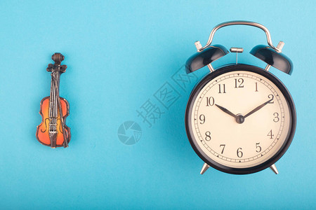 时间管理概念闹钟和蓝背景小提琴复背景图片
