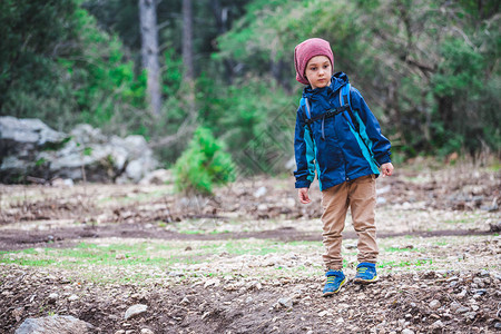 一个背着包的男孩正沿着森林小径走一个探索世界的孩子孩子图片