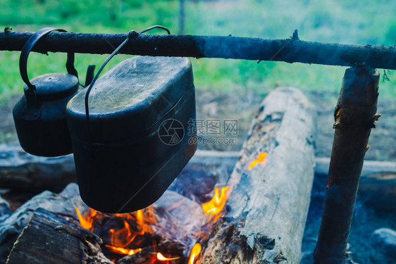 篝火上方的大锅和水壶在大自然中烹饪食物户外晚餐木柴和树枝着火积极休息图片