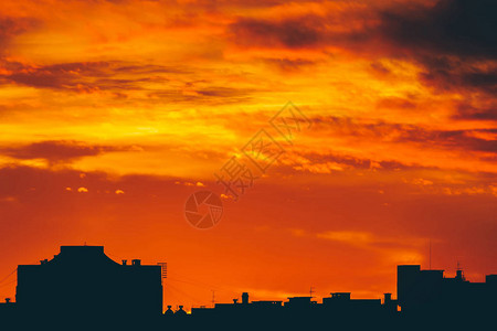 城市景观与生动的火热黎明令人惊叹的温暖戏剧多云天空在城市建筑的黑暗轮廓之上橙色的阳光阴天中日出的大气背图片