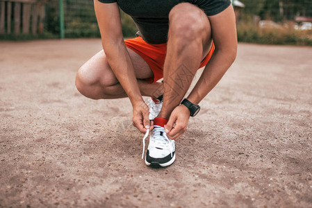 一个夏天在城市的沥青上的运动员自然健身休闲装晒黑的皮肤图片