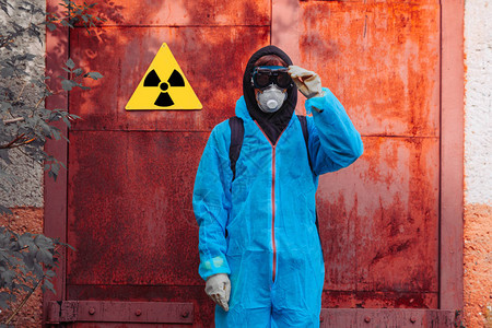 身穿蓝色防护服的男子接近辐射中毒的图标环境污染和生图片