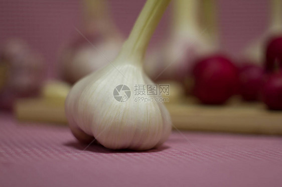 新鲜的红萝卜红洋葱和大蒜木板上的新鲜蔬菜红色背景上的蔬菜有用图片