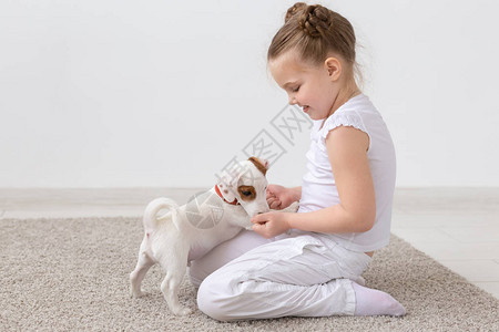 动物儿童和宠物概念小女孩与可爱的小狗一起坐图片