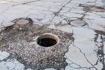 在柏油路上打开不安全的下水道沙井道路上的危险坑街道上的背景图片