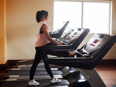 健身锻炼在运动场上跑步的合适妇女通过体操健康生活方式的概念图片