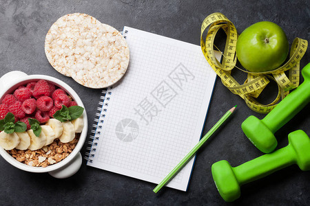 健康食品和健身理念沙拉水果早餐麦片和健身器材顶视图平躺图片