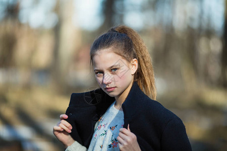 一个12岁可爱女孩的肖像在春天公园拍摄背景图片