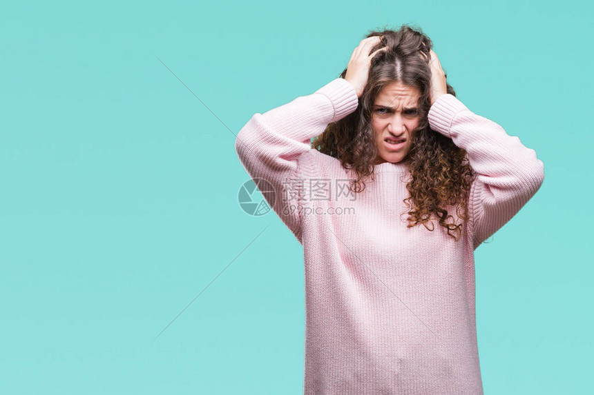 美丽的黑发卷年轻女孩穿着粉红色的冬季毛衣在孤立的背景下遭受头痛绝望和压力因为疼痛和偏头痛图片