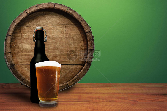 木桶啤酒杯和黑瓶子放在红木桌头上美图片