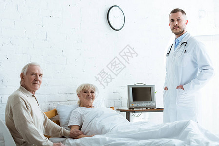 白大衣医生老年男子和在诊所躺在床上的有微图片