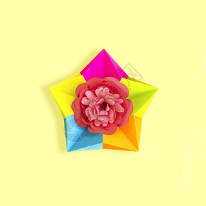 折纸五彩星与纸花在黄色背景的中心纸艺和工艺时髦的爱好最图片
