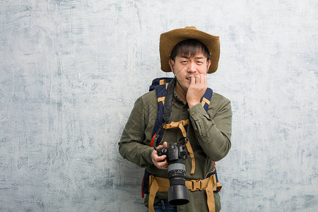 年轻探险家男子拿着相机咬钉子紧图片