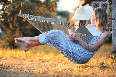 美丽的少女在秋天户外躺着看书图片