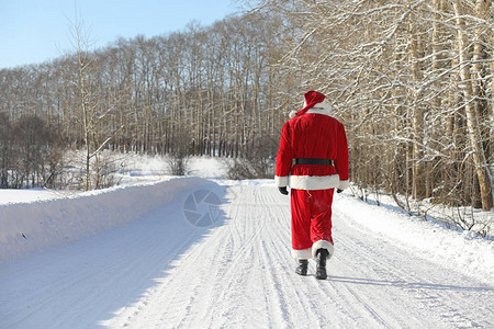 圣诞老人带着外面的礼物来了穿着红色西装留着胡子戴着眼镜的圣诞老人正沿着通往圣诞节的路走圣诞老人给孩图片