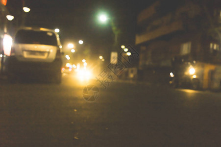 加尔各答市在有雾的雨夜与运动模糊效果汽车耀斑光效果逼真的白色发光圆形大灯光束软焦点浅景深复图片