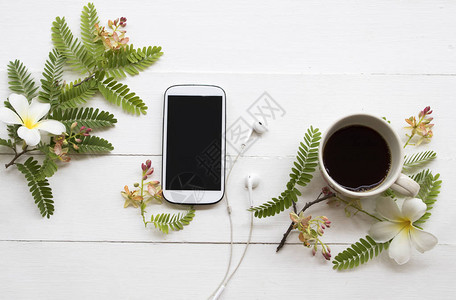 手机热咖啡和花安排背景白色的图片