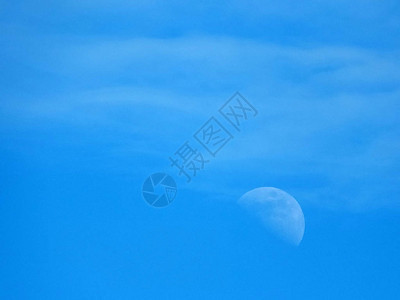 蔚蓝的天空中微弱的月亮和云彩图片