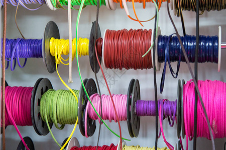 多彩姿的线程和丝带卖丝带卷轴的商店的背景缝纫和创意材料女图片
