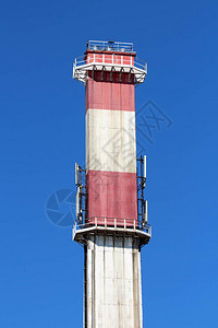具有两个金属安全平台和多个手机发射器的混凝土高红白工业烟囱在清澈图片