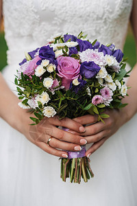 新娘近亲手握着带有粉红玫瑰和白菊背景图片