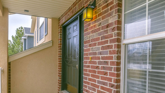 带有小门廊和经典红砖墙的房屋的清晰全景外墙绿色的前门可以看到欢迎图片