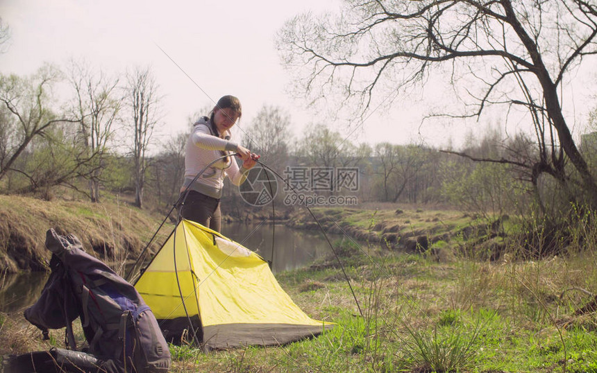 女人在河边的森林里搭建了旅游帐篷图片