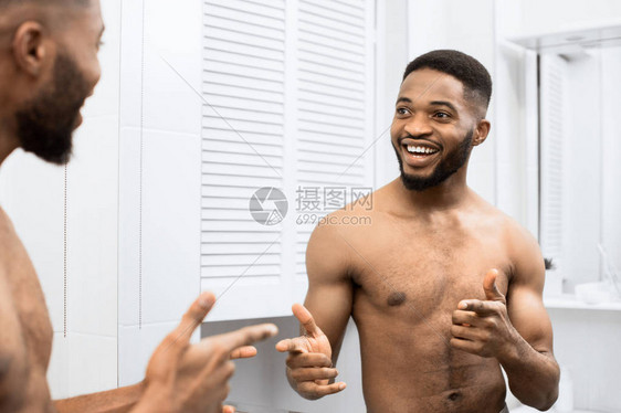 光着身躯的笑脸男人在浴室照镜子时用手指着手图片