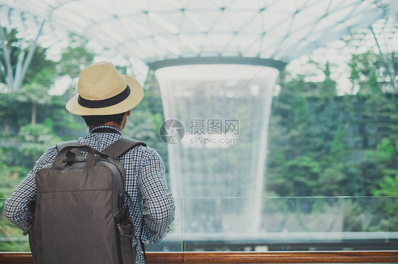 亚洲旅行者站着寻找朱厄尔尚吉机场美丽的雨旋图片