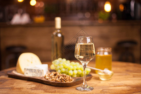 旧木桌上的白葡萄酒奶酪和葡萄美味的葡萄好饮图片