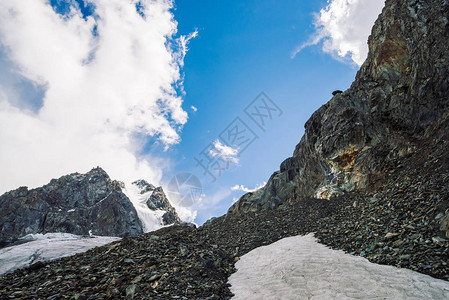 山脉上的雪蓝色多云的天空下的大气雪脊奇妙的巨石爬上高山高地雄伟自然的背景图片