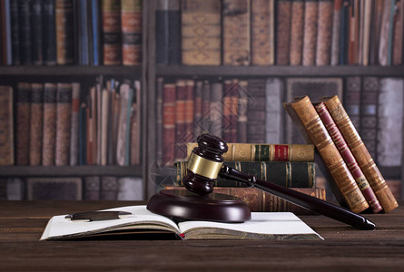 法律办公室法律书籍和木制法官的手图片