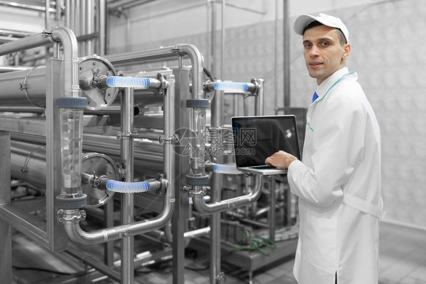 手拿着灰板的技术人员在奶制品厂部门站立时设置了生产线图片