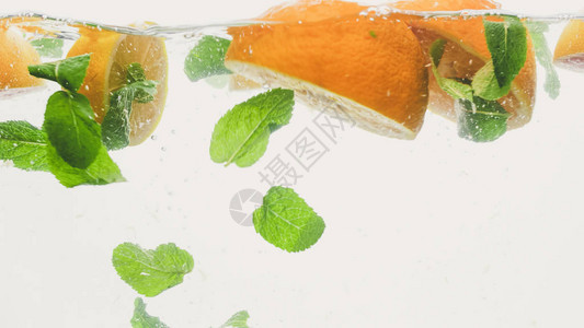 剪切新鲜多汁橙子和薄荷叶的紧贴照片图片