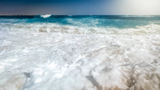 海浪在海滩沙上摇欲坠阳光明媚的海图片
