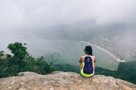 成功的女徒步旅行者在海边山顶欣赏美丽的景色图片