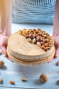 配有核桃杏仁麦当米和蓝木背景的栗子花椰子的原始坚果蛋糕健康背景图片