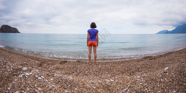 一个女人独自走在海边女孩看着大海和日落晚上在沙滩上散步布鲁内特在图片