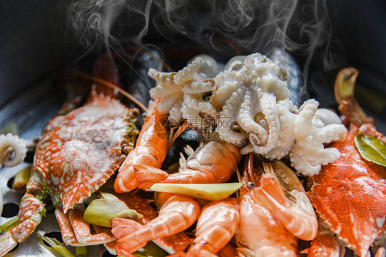 海鲜盘贝类配蒸虾贻贝用香草和香料在火锅中煮沸图片