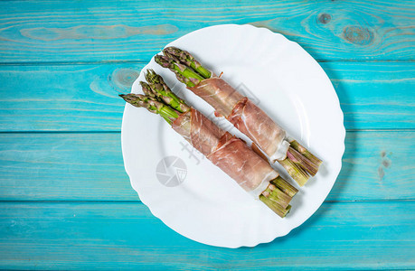 蓝木桌上的鲜嫩的Asparagus包装图片