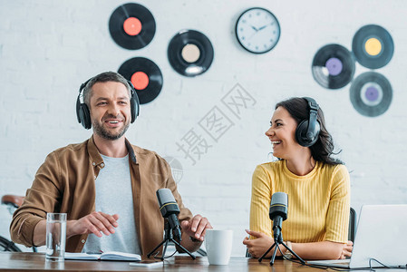 两个快乐的电台主播耳机录音播客在演播室背景图片