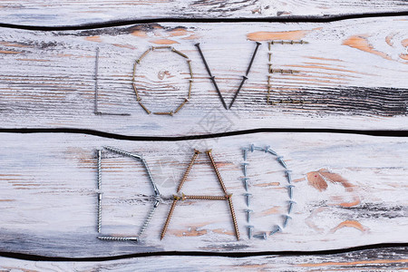 从金属螺丝上给爱爸下个记号以木制背景为父亲日的爱图片