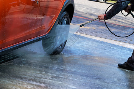 在自助洗车时用清洁水洗男子在户外洗车图片
