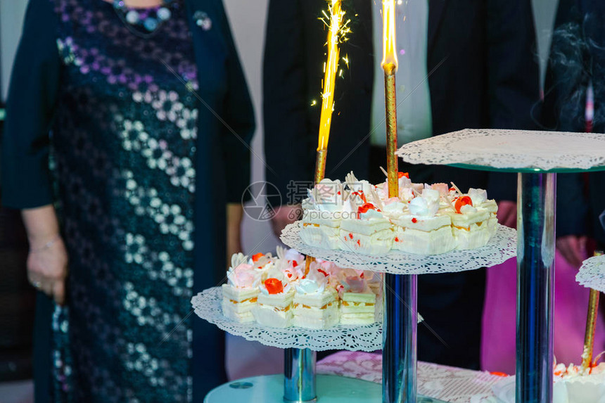 与烟花的婚礼蛋糕在一个黑暗的背景冷火图片