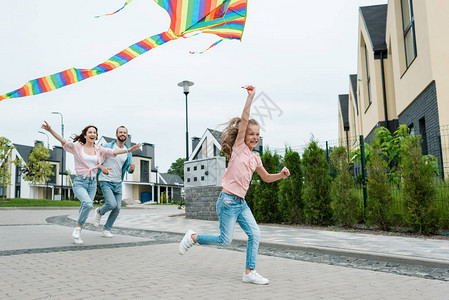 快乐的孩子与多彩的风筝跑动在街上幸图片