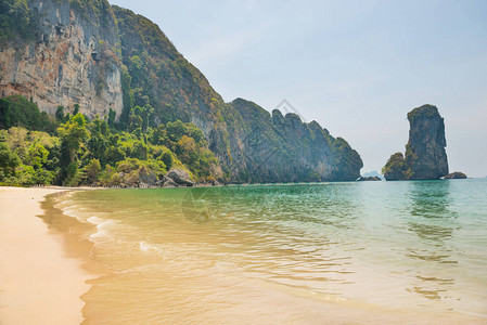 美丽的海滩绿松石海水和岩石山的图片