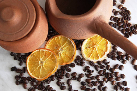 土耳其人棕色粘土盘咖啡和罐牛奶的手柄大壶大量烤咖啡豆桌上背景