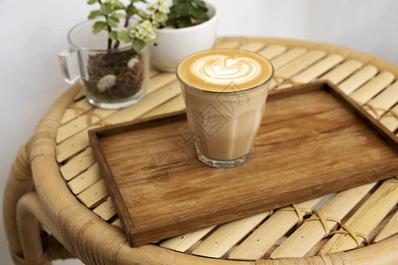 竹桌上木托盘中的热拿铁咖啡图片