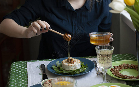 烤咖啡菜加菠菜煮鸡蛋碗加蜂蜜和核桃以及两杯葡萄酒图片