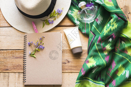 防晒霜香水笔记本围巾和生活方式女帽子在背景木上放松夏季图片